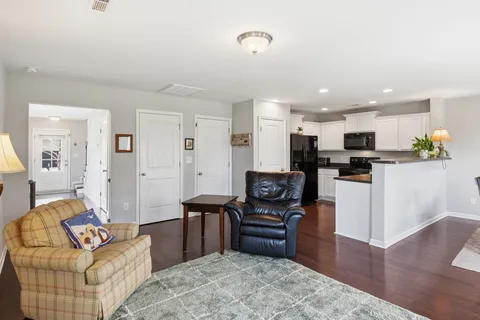 a living room with furniture and a dining table with kitchen view