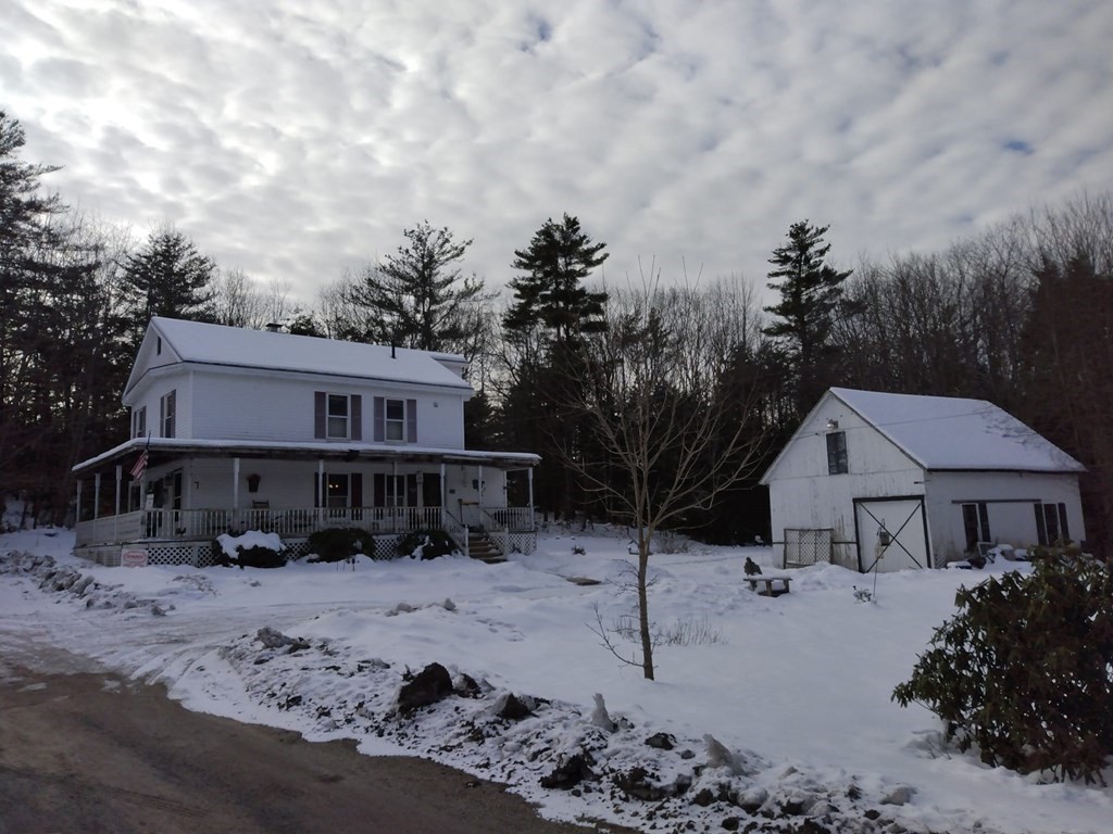 a front view of a house with a yard covered in snow