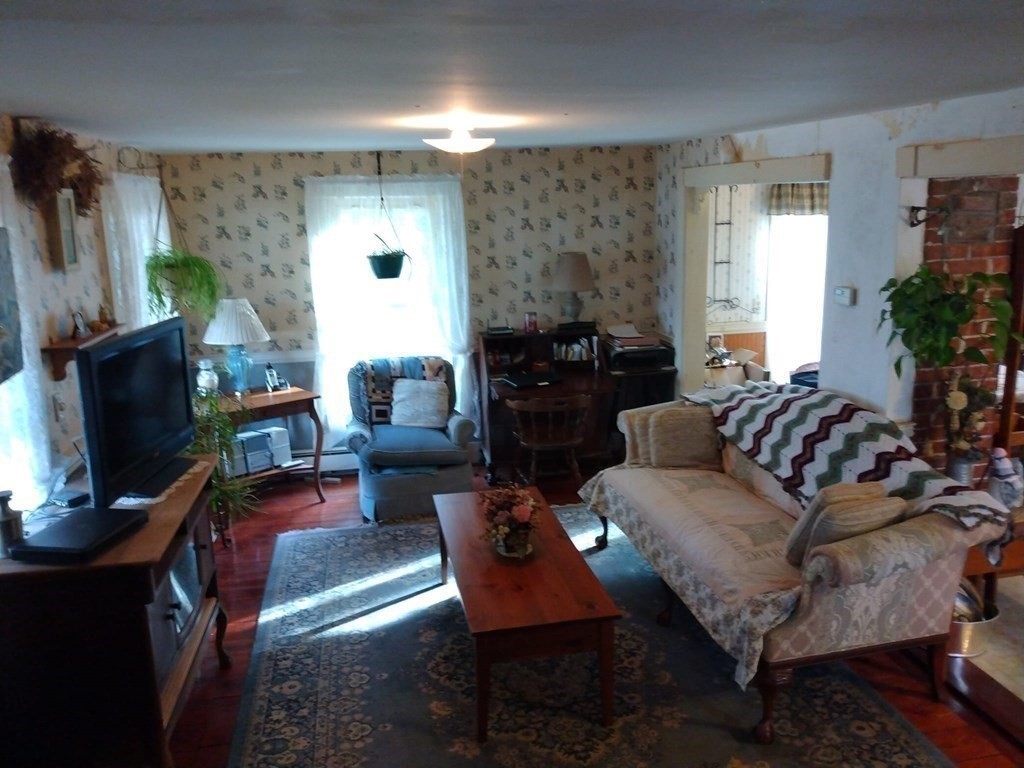 7 Maple Place Winchendon, MA 01475 - Photo 14 of 28 a living room with furniture a flat screen tv and a fireplace