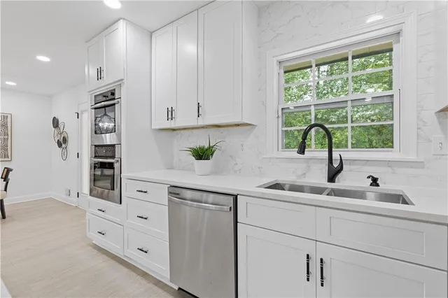a kitchen with cabinets appliances a sink and a window