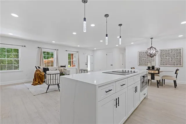 a large kitchen with kitchen island a sink a stove a dining table and chairs