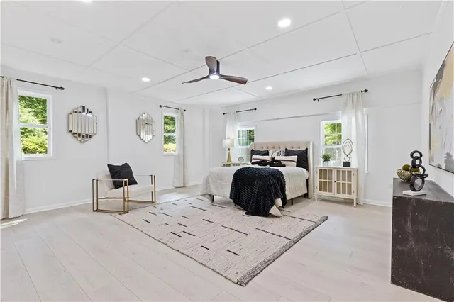 a bedroom with a bed large window and couch