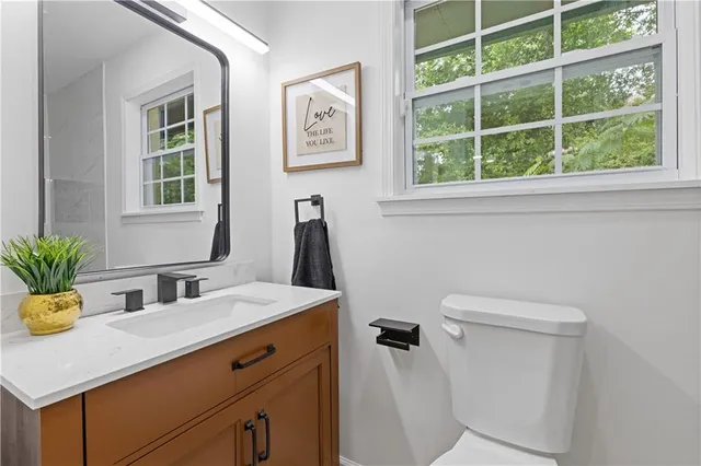 a bathroom with a sink a toilet and a window