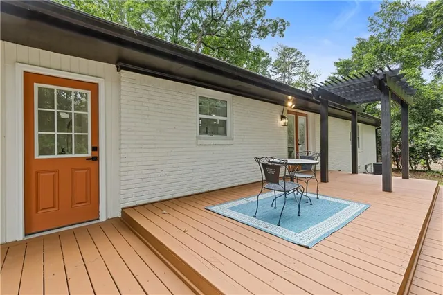 a patio with a table and chairs and potted plants