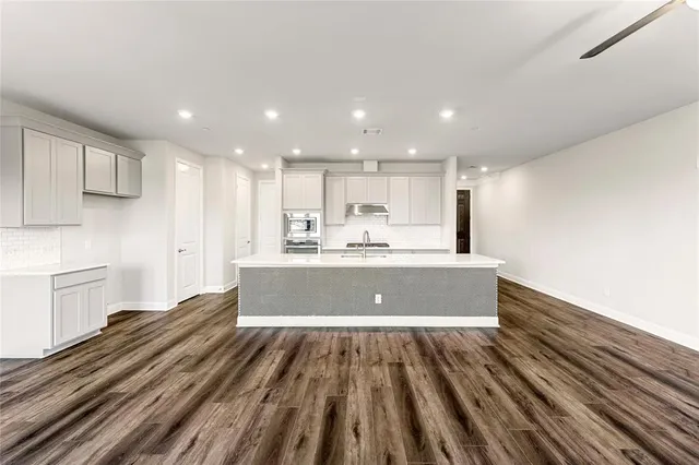a kitchen with a sink a stove top oven and refrigerator
