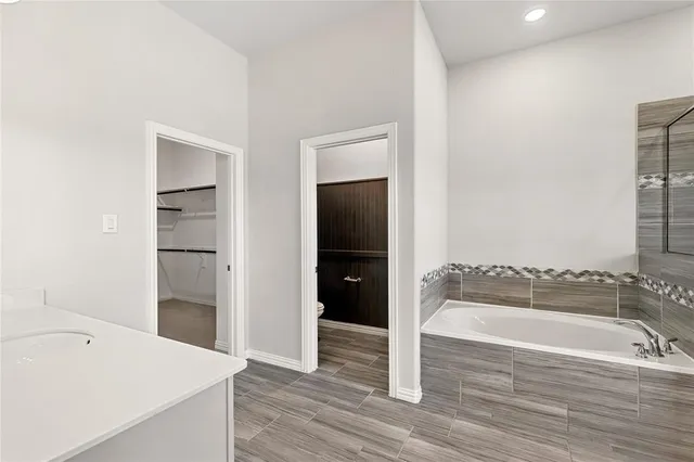 an empty room with chandelier fan and windows
