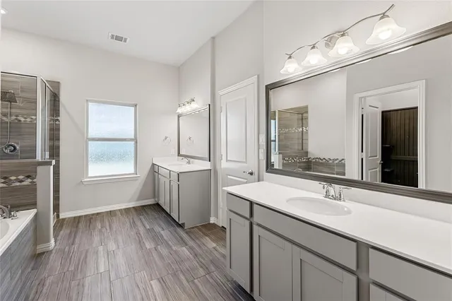 a bathroom with a bathtub sink and mirror