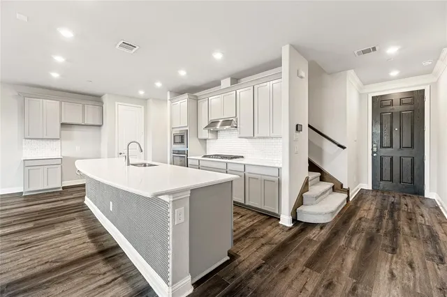 a kitchen with white cabinets and sink