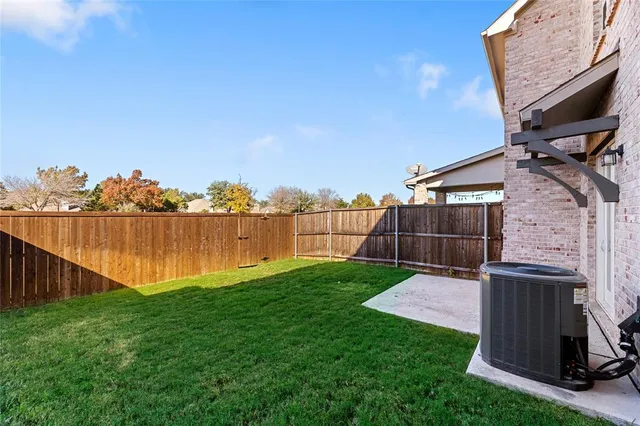 a view of backyard with potted plants and wooden fence