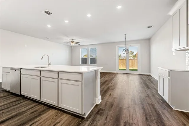 a large white kitchen with wooden floors and white walls