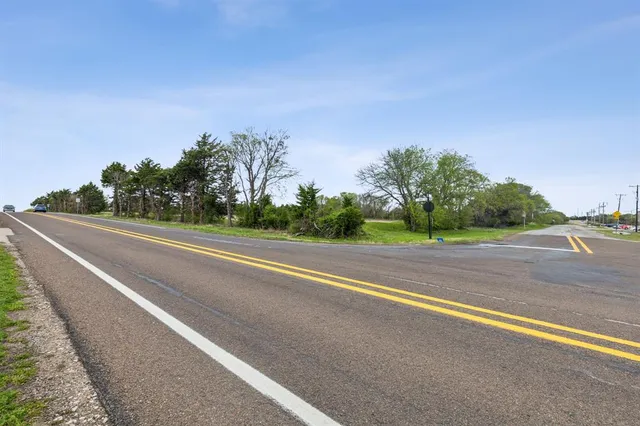 a view of a road with a houses in the background