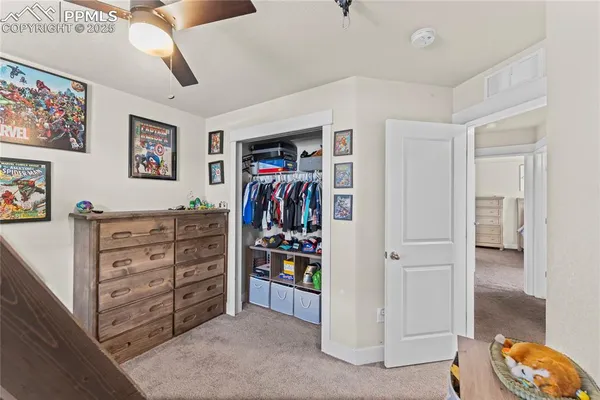 a view of walk in closet with clothes and shoes