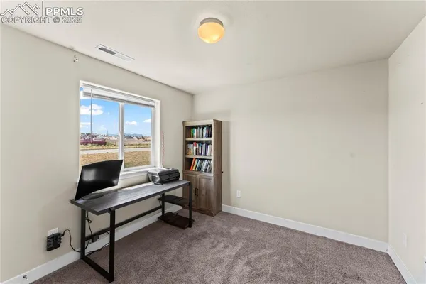 a view of a workspace with furniture and a window