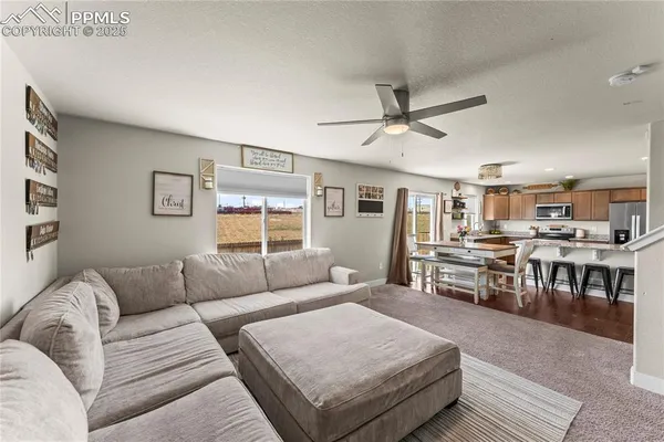 a living room with furniture kitchen view and a window