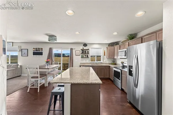 a kitchen with stainless steel appliances granite countertop a refrigerator and a stove top oven