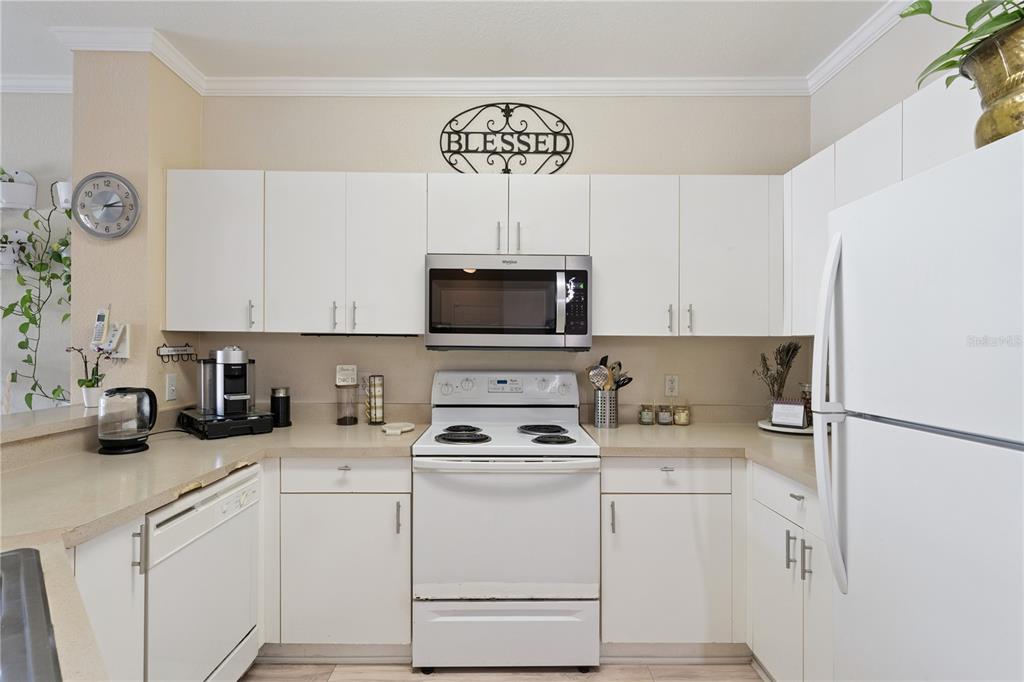 3751 Conroy Road, Unit 2325 Orlando, FL 32839 - Photo 11 of 31 a kitchen with white cabinets and white appliances