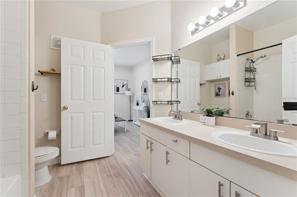 3751 Conroy Road, Unit 2325 Orlando, FL 32839 - Photo 17 of 31 a spacious bathroom with a double vanity sink a mirror and a toilet
