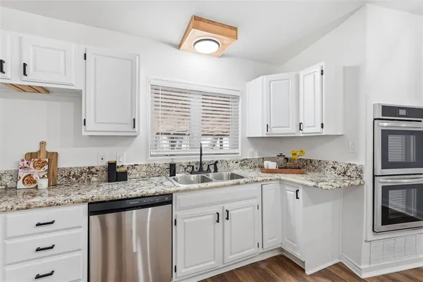 a kitchen with stainless steel appliances kitchen island granite countertop a stove a sink and a refrigerator
