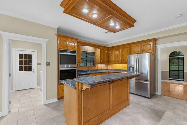 a kitchen with stainless steel appliances granite countertop a stove refrigerator and a sink