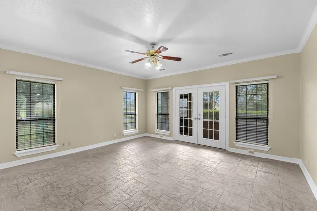 a view of an empty room with a window and a kitchen