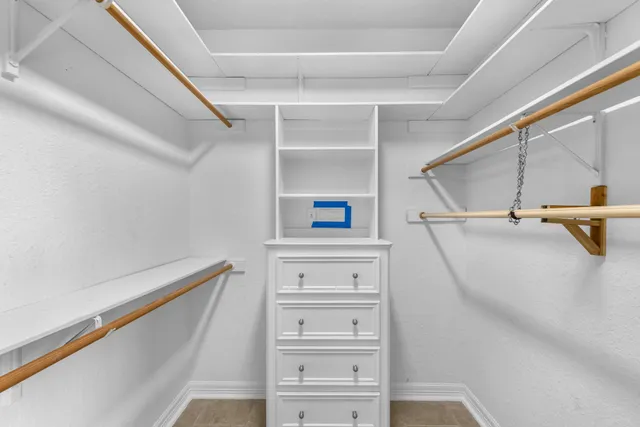 a view of walk in closet with empty racks