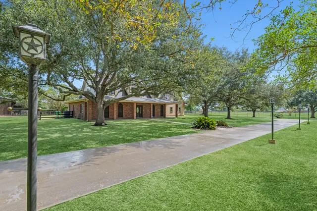 a front view of a house with a yard and trees