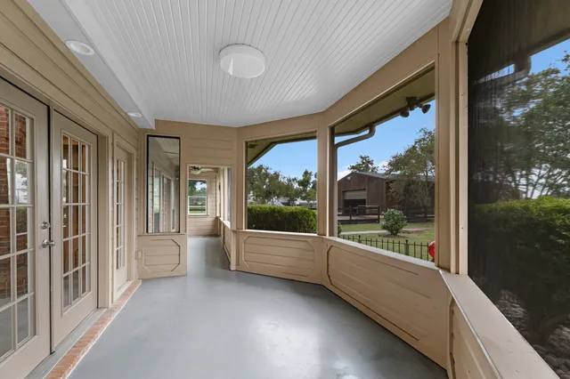 a view of a porch with furniture and floor to ceiling window