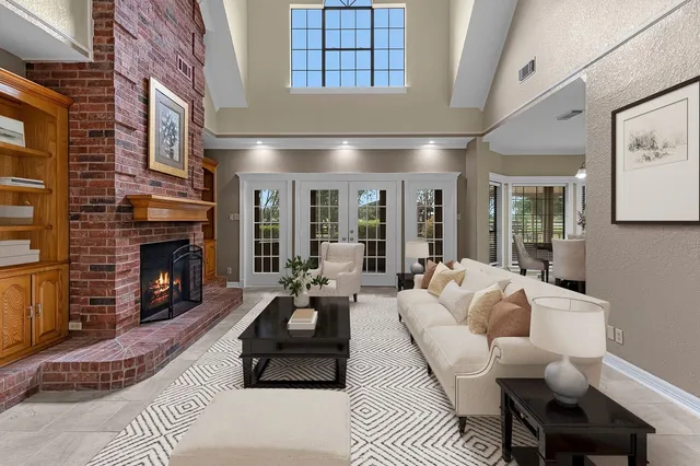 a living room with furniture fireplace and a large window