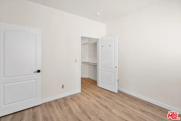 an empty room with wooden floor and mirror