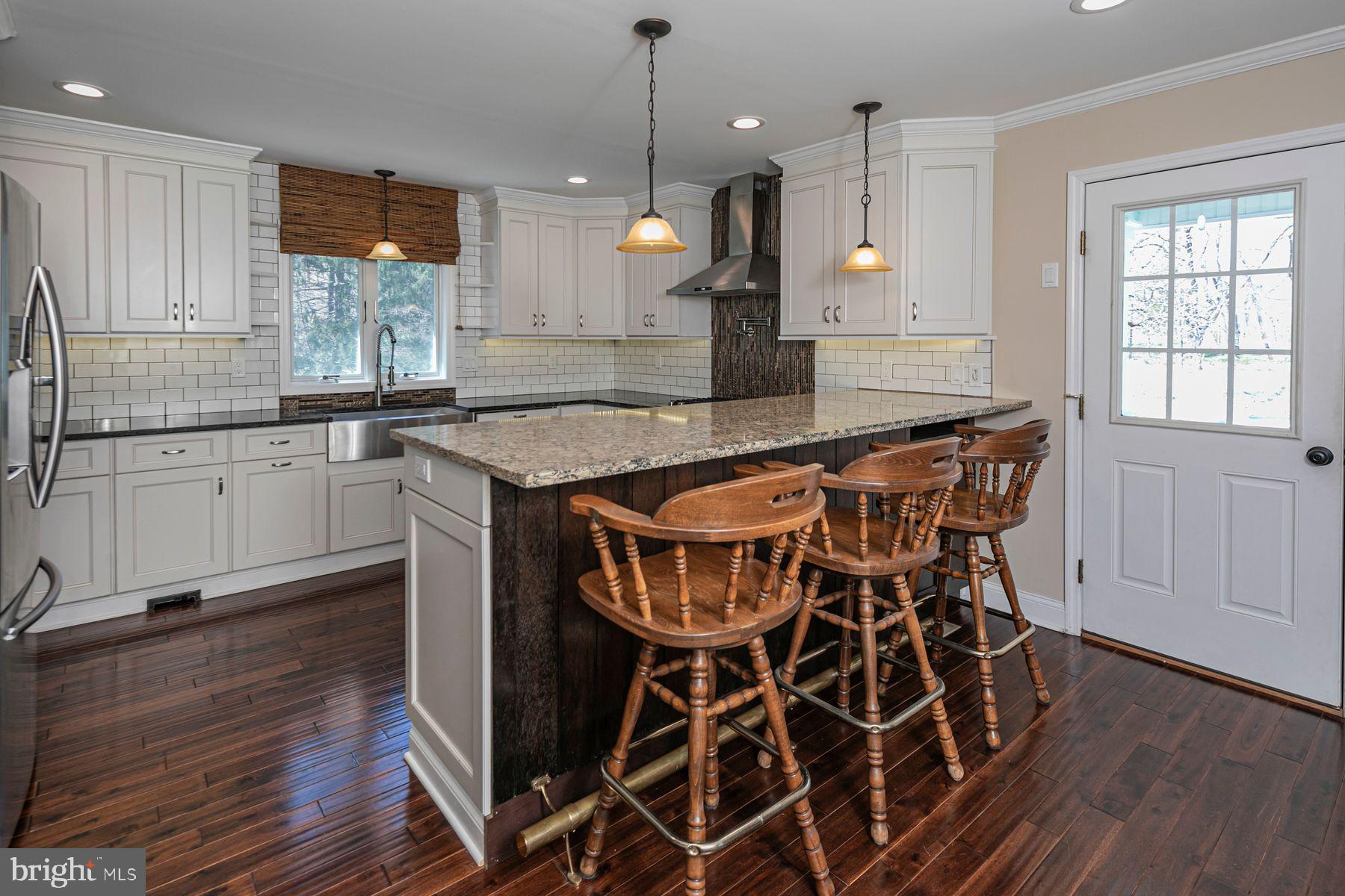 310 Hollow Road Skillman, NJ 08558 - Photo 10 of 32 a kitchen with stainless steel appliances granite countertop a kitchen island a stove and a wooden floors
