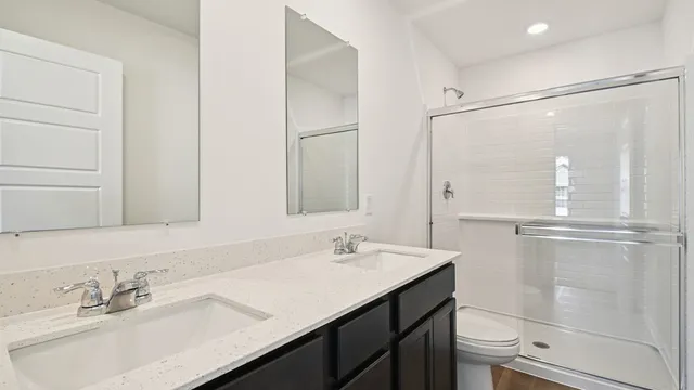 a bathroom with a shower sink vanity and mirror