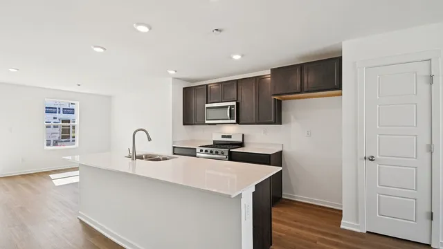 a kitchen with a sink cabinets and wooden floor
