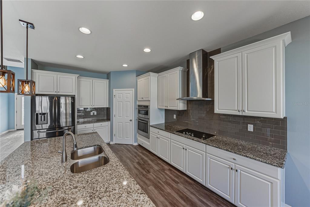 7628 Surf Reed Way Wesley Chapel, FL 33545 - Photo 15 of 76 a kitchen with granite countertop a sink and cabinets