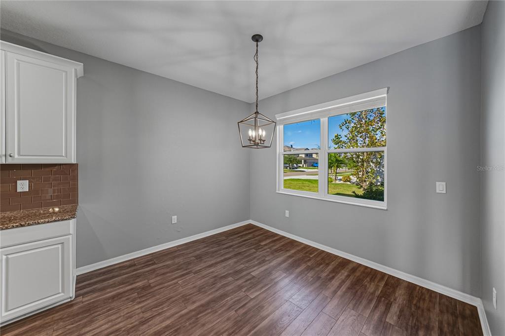 7628 Surf Reed Way Wesley Chapel, FL 33545 - Photo 18 of 76 a view of a room with wooden floor ceiling fan and window