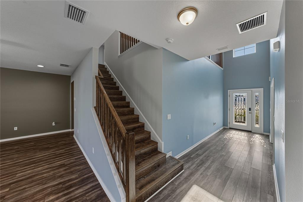 7628 Surf Reed Way Wesley Chapel, FL 33545 - Photo 26 of 76 a view of a hallway with wooden floor and staircase