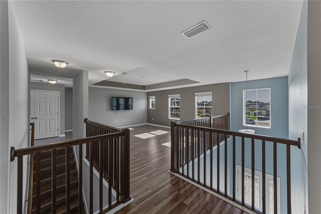 7628 Surf Reed Way Wesley Chapel, FL 33545 - Photo 30 of 76 a view of a hallway with wooden floor and stairs