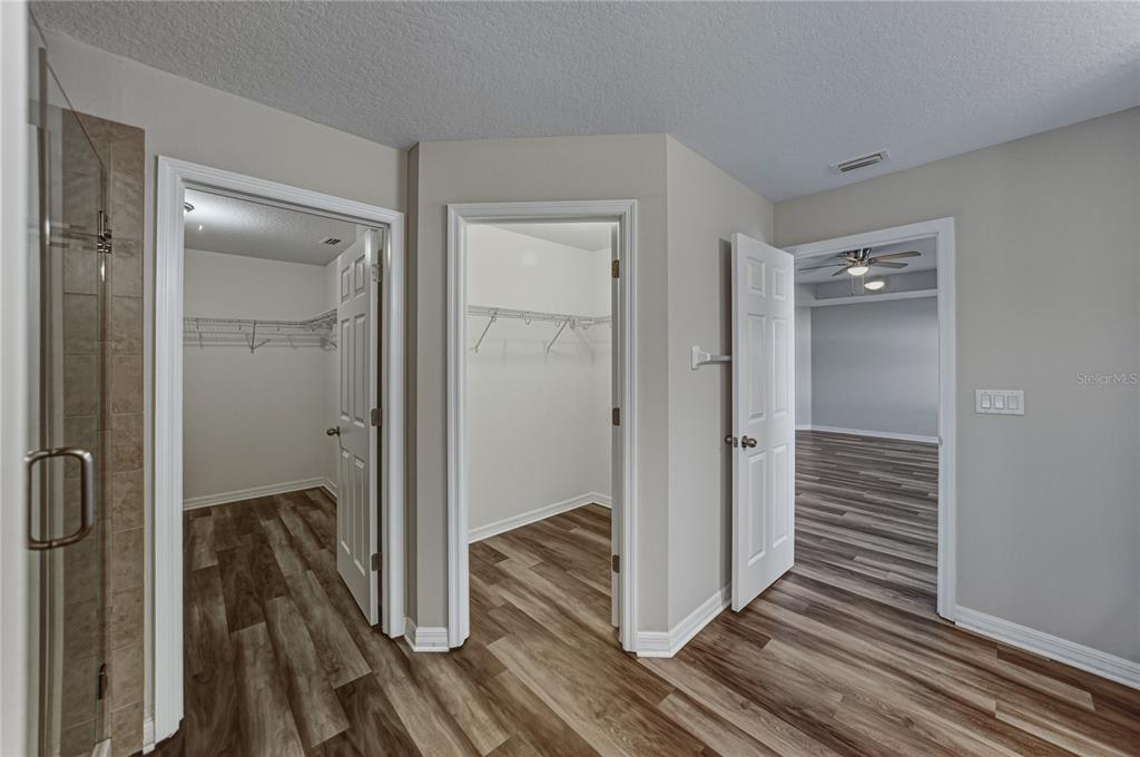 7628 Surf Reed Way Wesley Chapel, FL 33545 - Photo 39 of 76 a view of a hallway with wooden floor and staircase