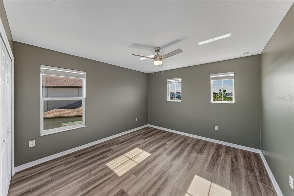 7628 Surf Reed Way Wesley Chapel, FL 33545 - Photo 40 of 76 a view of empty room with wooden floor and fan