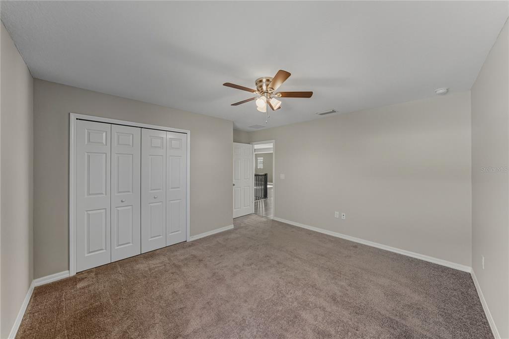 7628 Surf Reed Way Wesley Chapel, FL 33545 - Photo 48 of 76 a view of an empty room with a ceiling fan
