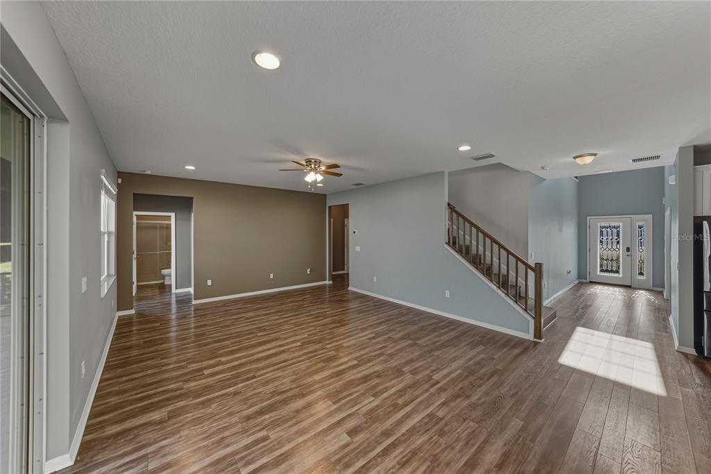 7628 Surf Reed Way Wesley Chapel, FL 33545 - Photo 7 of 76 a view of a room with wooden floor and stairs