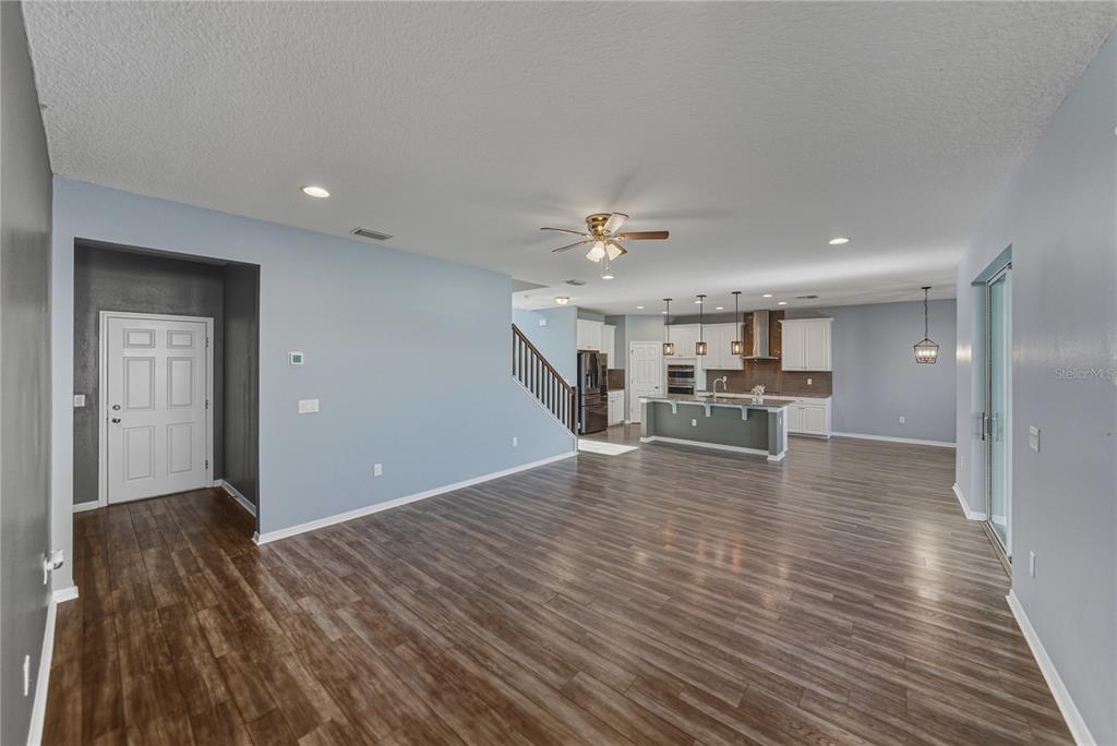 7628 Surf Reed Way Wesley Chapel, FL 33545 - Photo 8 of 76 a view of a livingroom with wooden floor and staircase