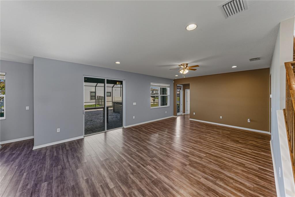 7628 Surf Reed Way Wesley Chapel, FL 33545 - Photo 10 of 76 a view of an empty room with wooden floor and a window