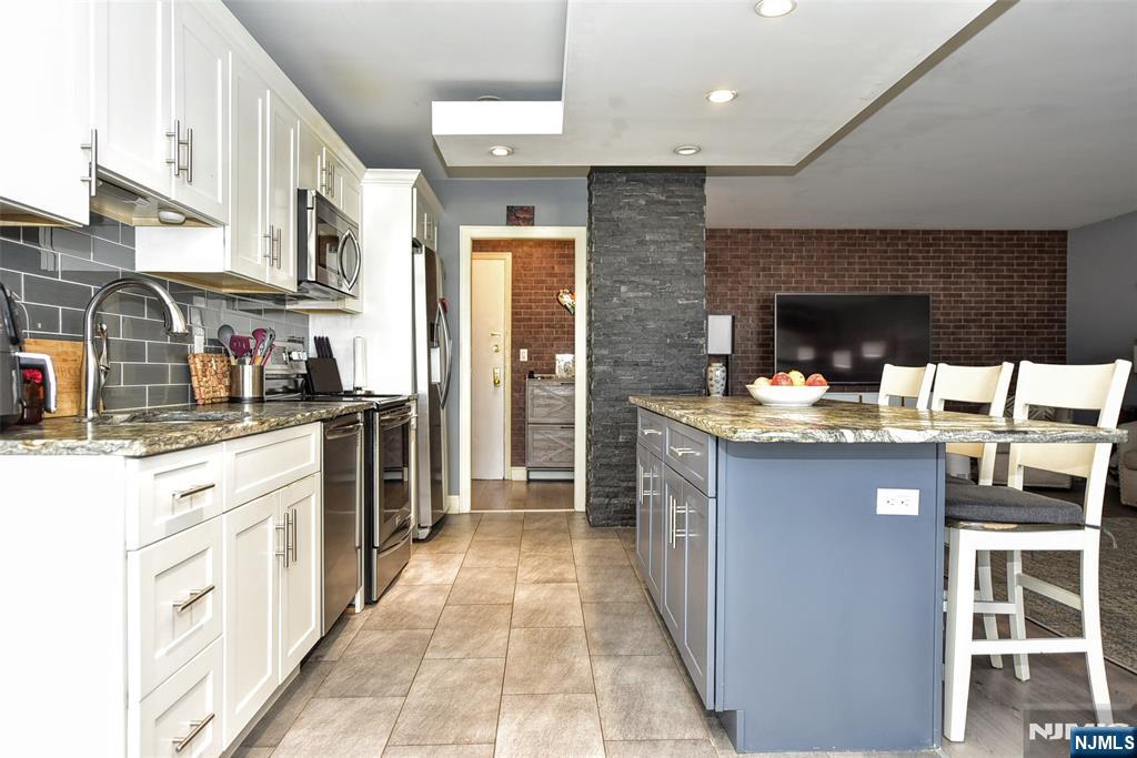 301 Beech Street, Unit 2F Hackensack, NJ 07601 - Photo 9 of 21 a kitchen with stainless steel appliances a sink stove and cabinets