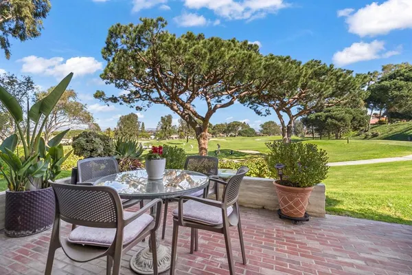 a view of a patio with furniture and a garden