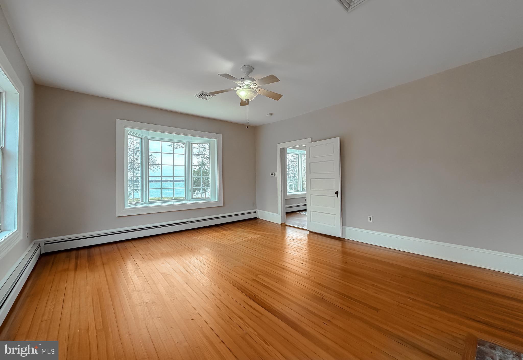 2790 Spout Lane Lusby, MD 20657 - Photo 54 of 95 an empty room with wooden floor chandelier fan and windows