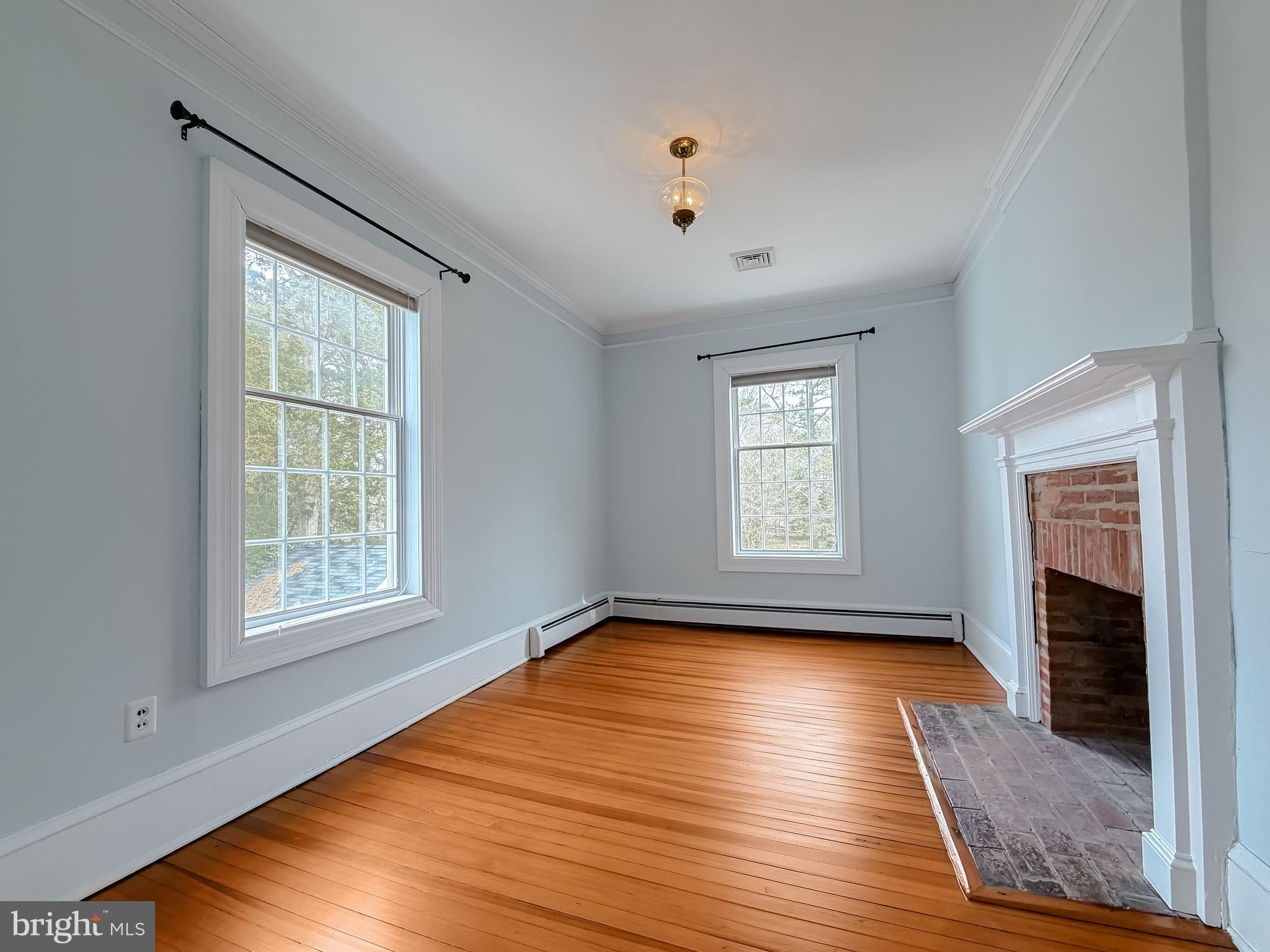 2790 Spout Lane Lusby, MD 20657 - Photo 64 of 95 a view of an empty room with wooden floor fireplace and a window
