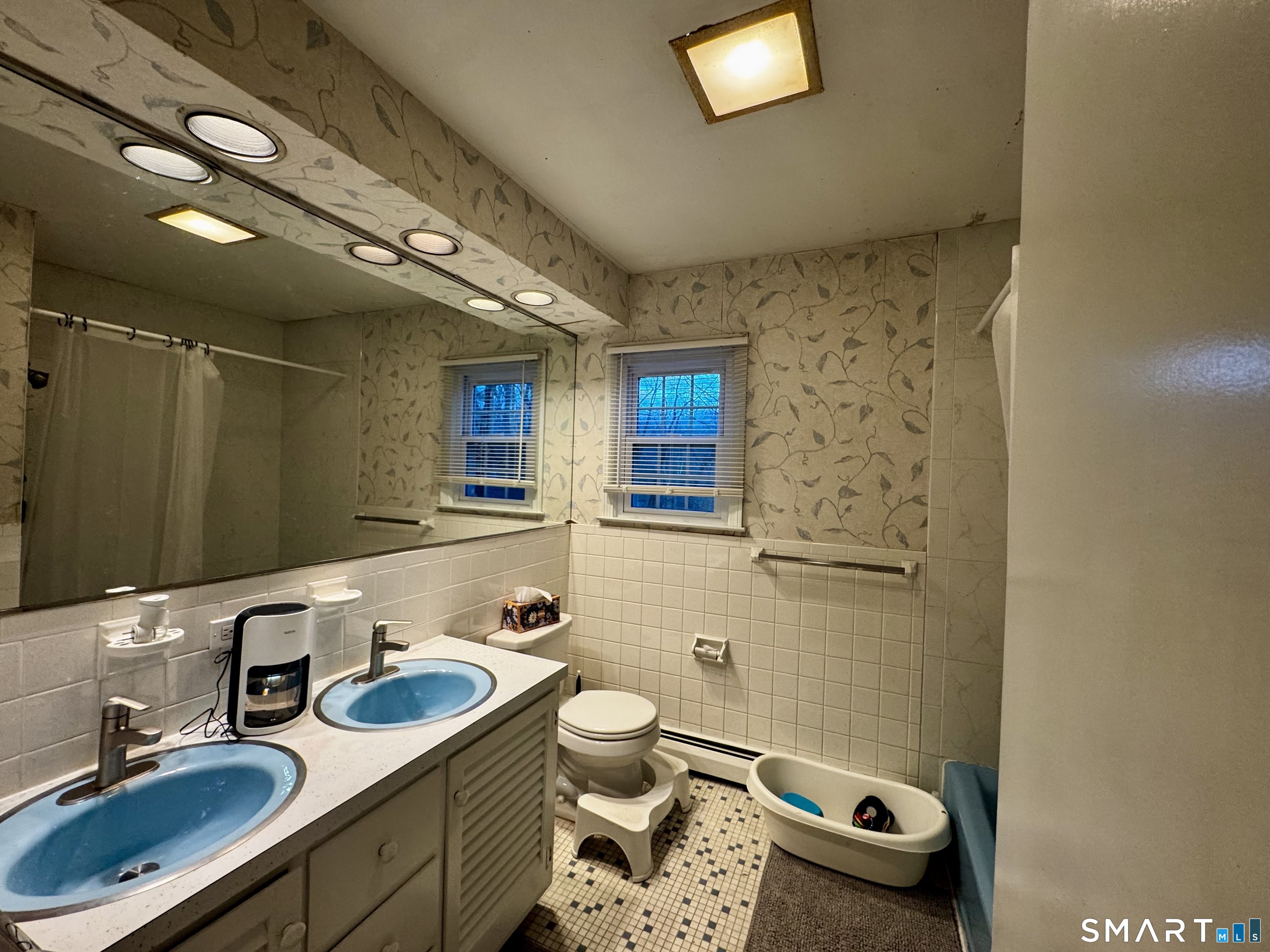 6 Redcoat Lane Trumbull, CT 06611 - Photo 20 of 30 a bathroom with a sink a toilet a mirror and shower curtain