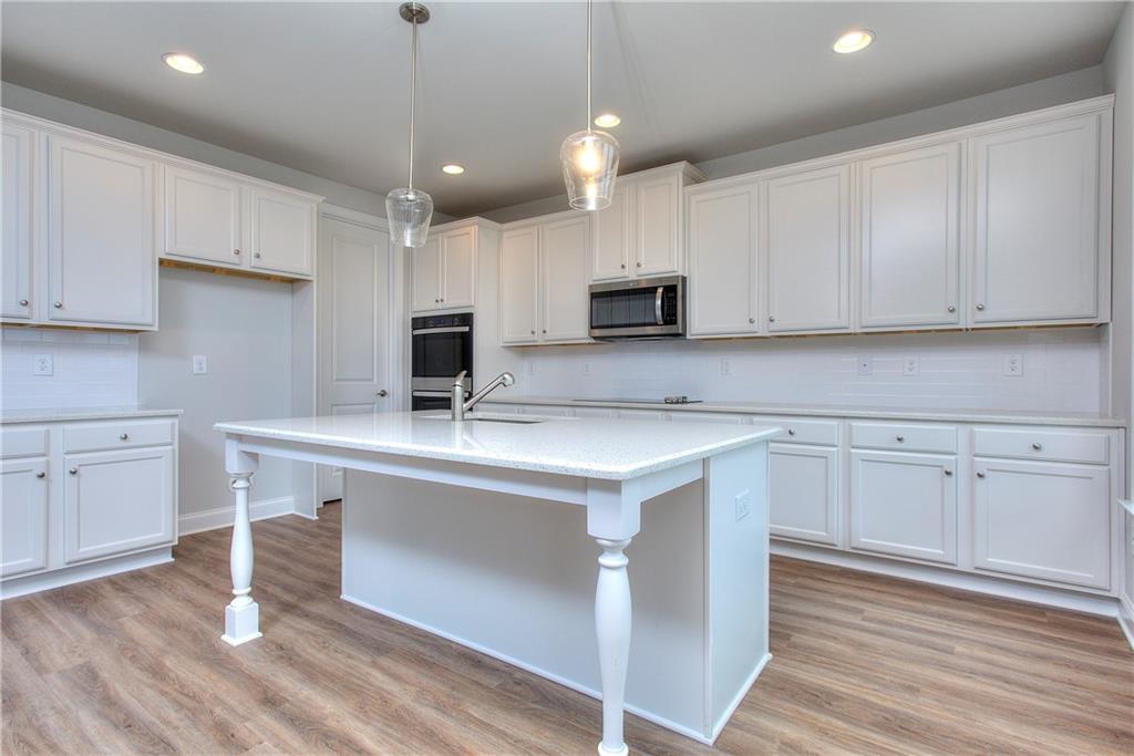 113 Swallowtail Lane Homer, GA 30547 - Photo 12 of 45 a kitchen with kitchen island granite countertop a sink appliances and cabinets