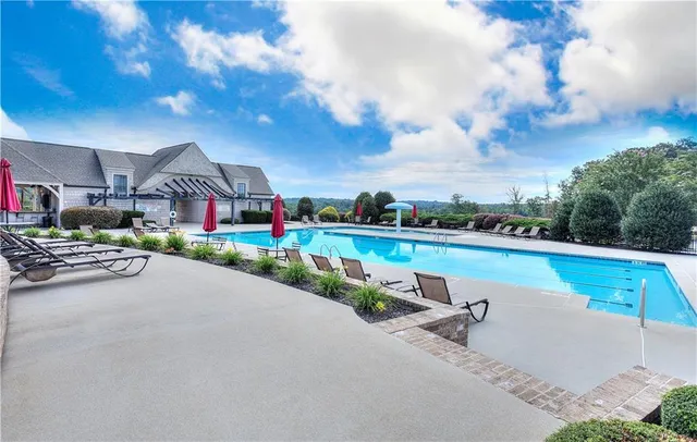 a view of swimming pool with a yard in front of it