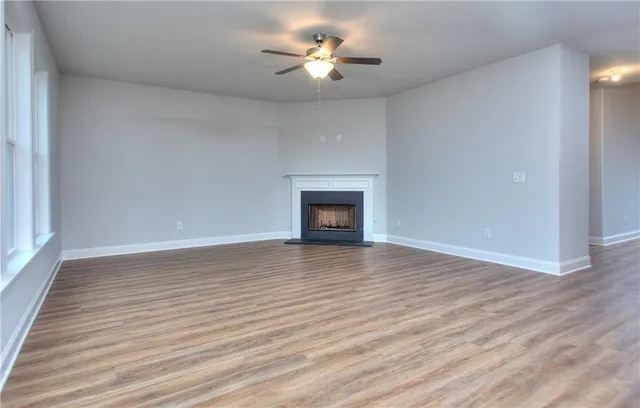 a view of room with wooden floor and a ceiling fan